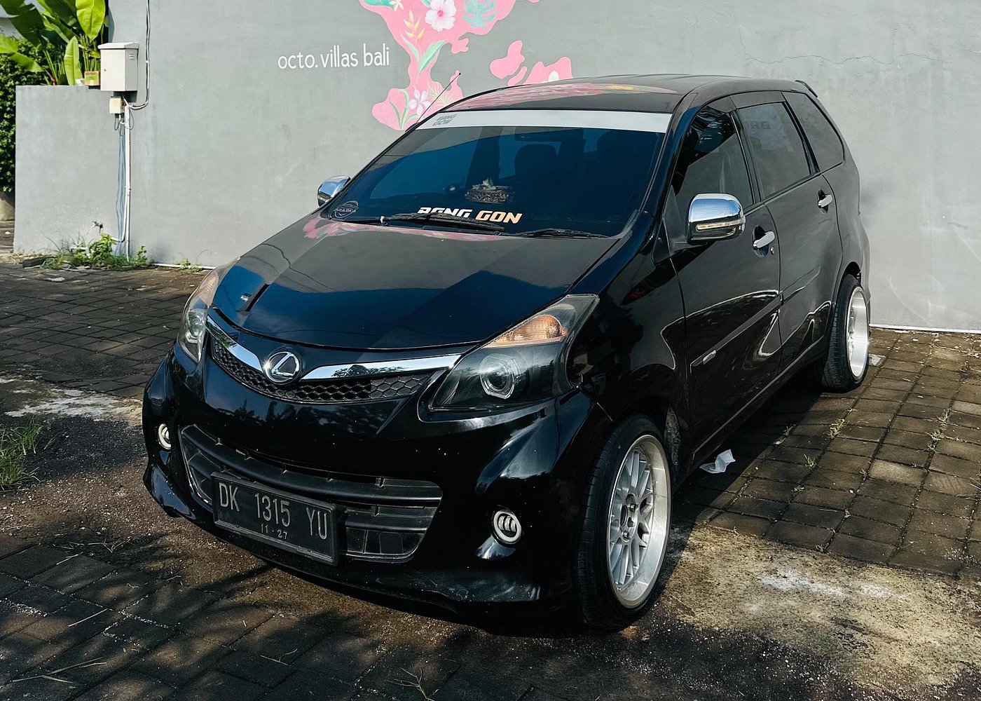 Private AHB transfer van waiting at Bali Ngurah Rai airport arrivals with driver holding a name sign