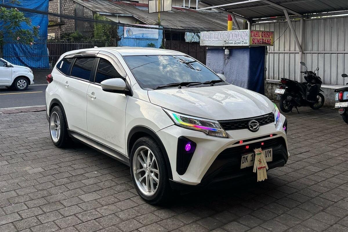 Modern white SUV ready for airport pickup outside a Kuta restaurant