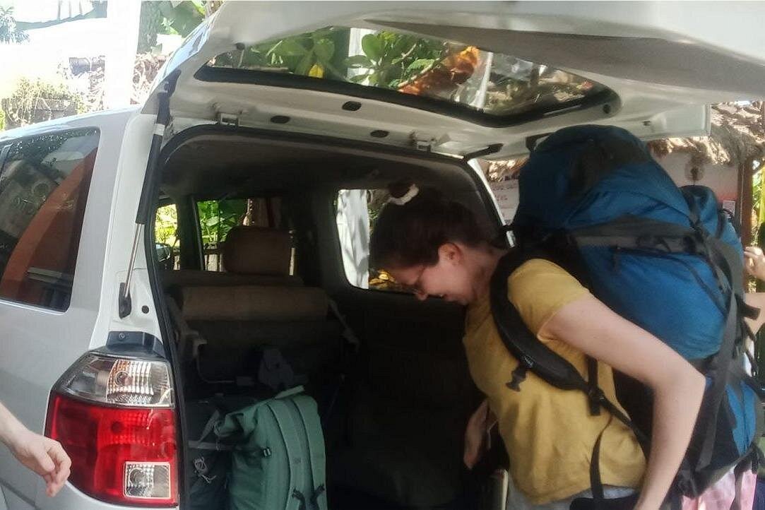 Driver helping traveller load luggage into the transfer vehicle