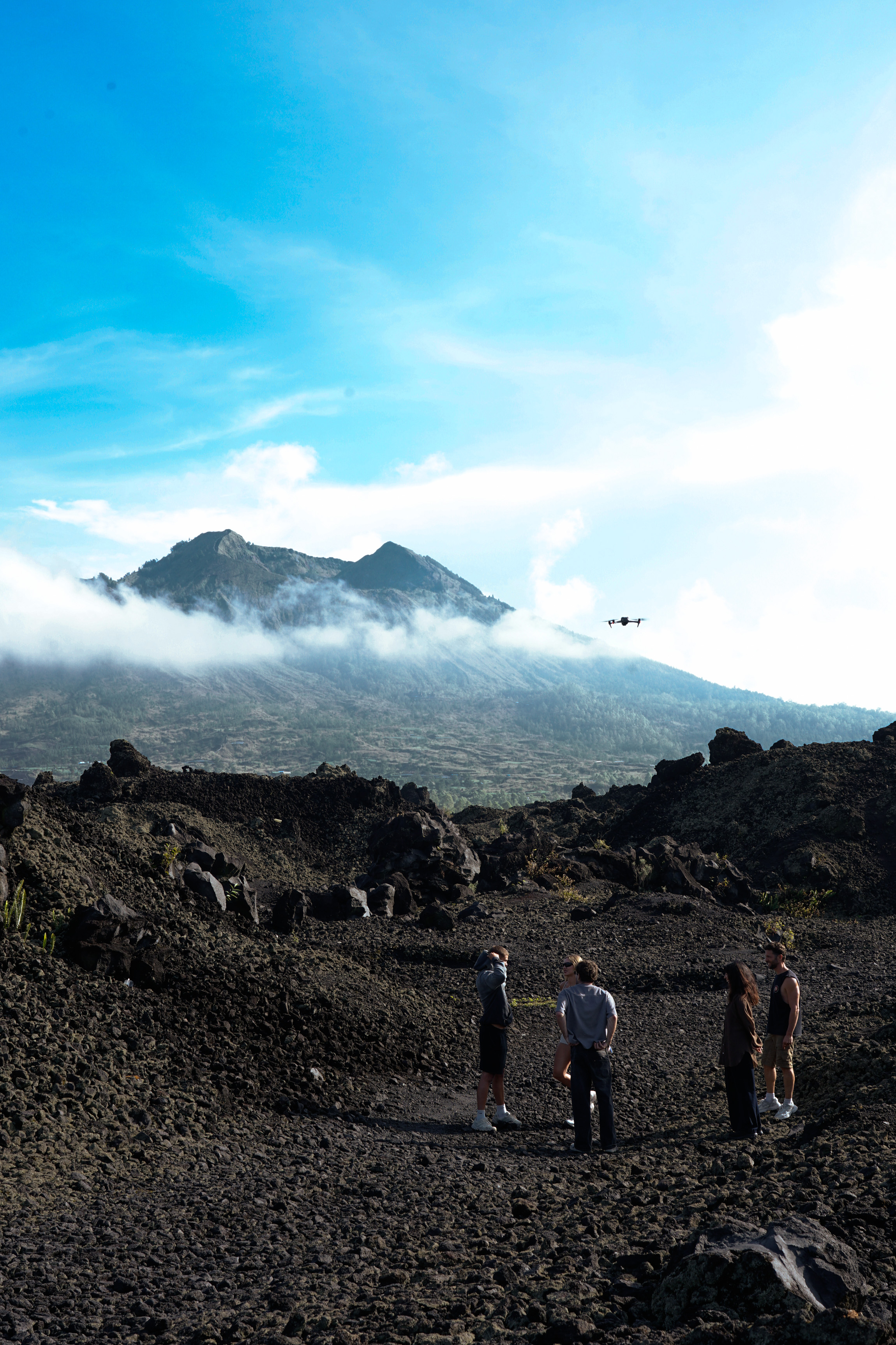 Travellers flying a drone over the Batur volcanic slope at dawn