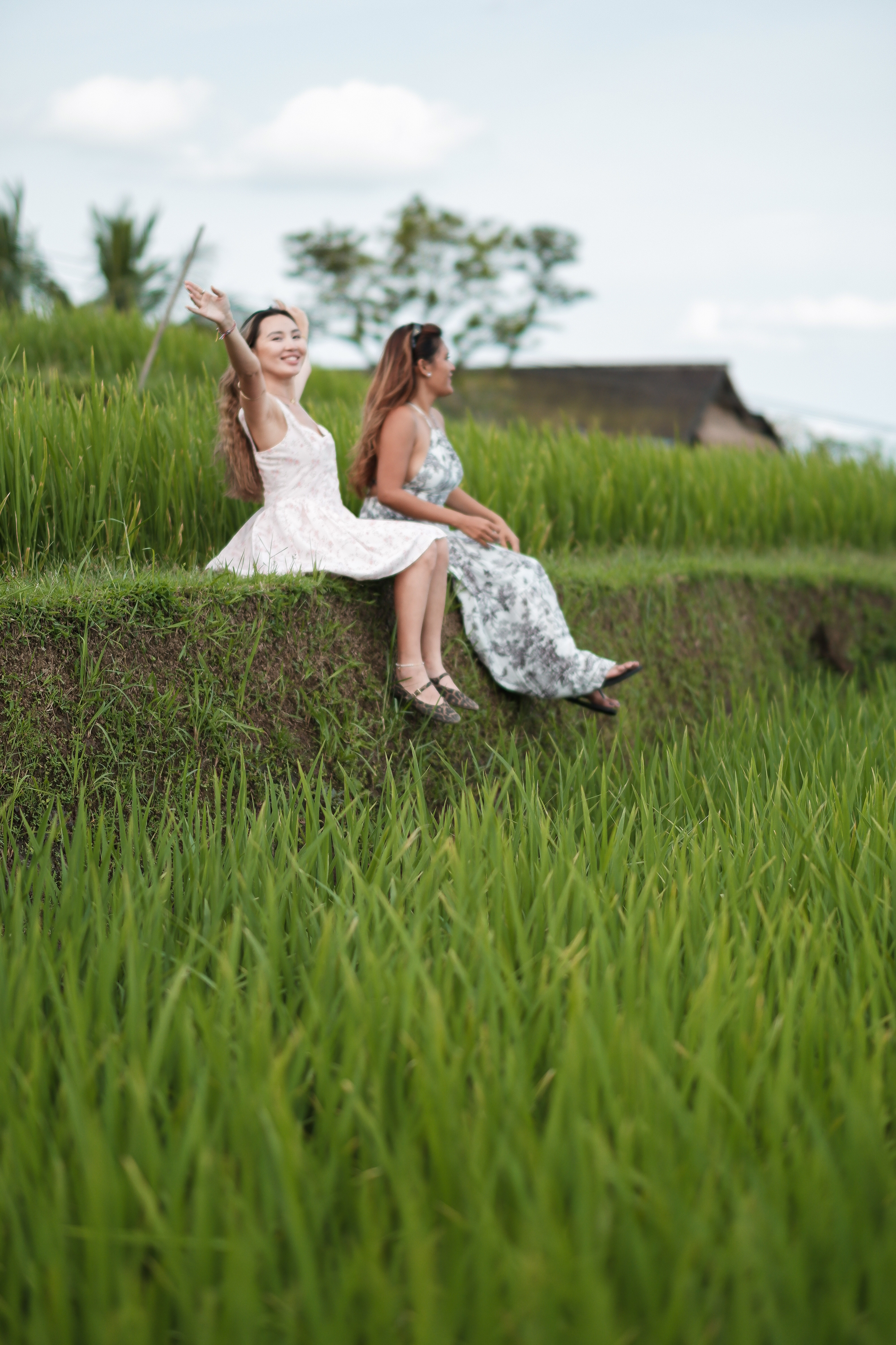 Two travellers seated at the edge of Jatiluwih rice terraces