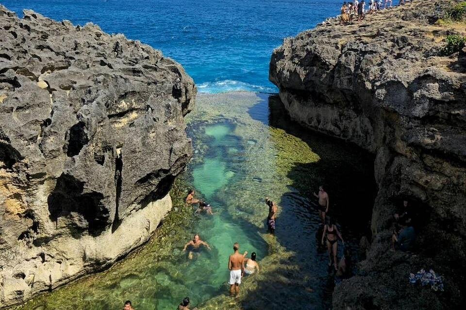 Tide pool of Angel''s Billabong with travellers exploring the rock formation