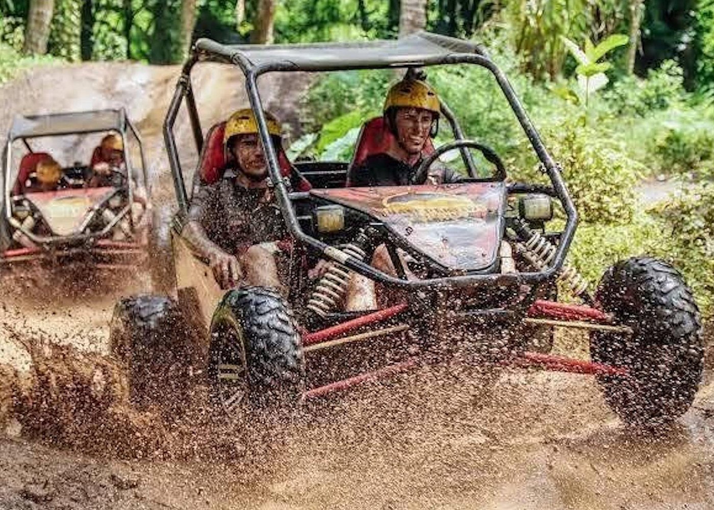 Pair of buggies side-by-side splashing through jungle mud