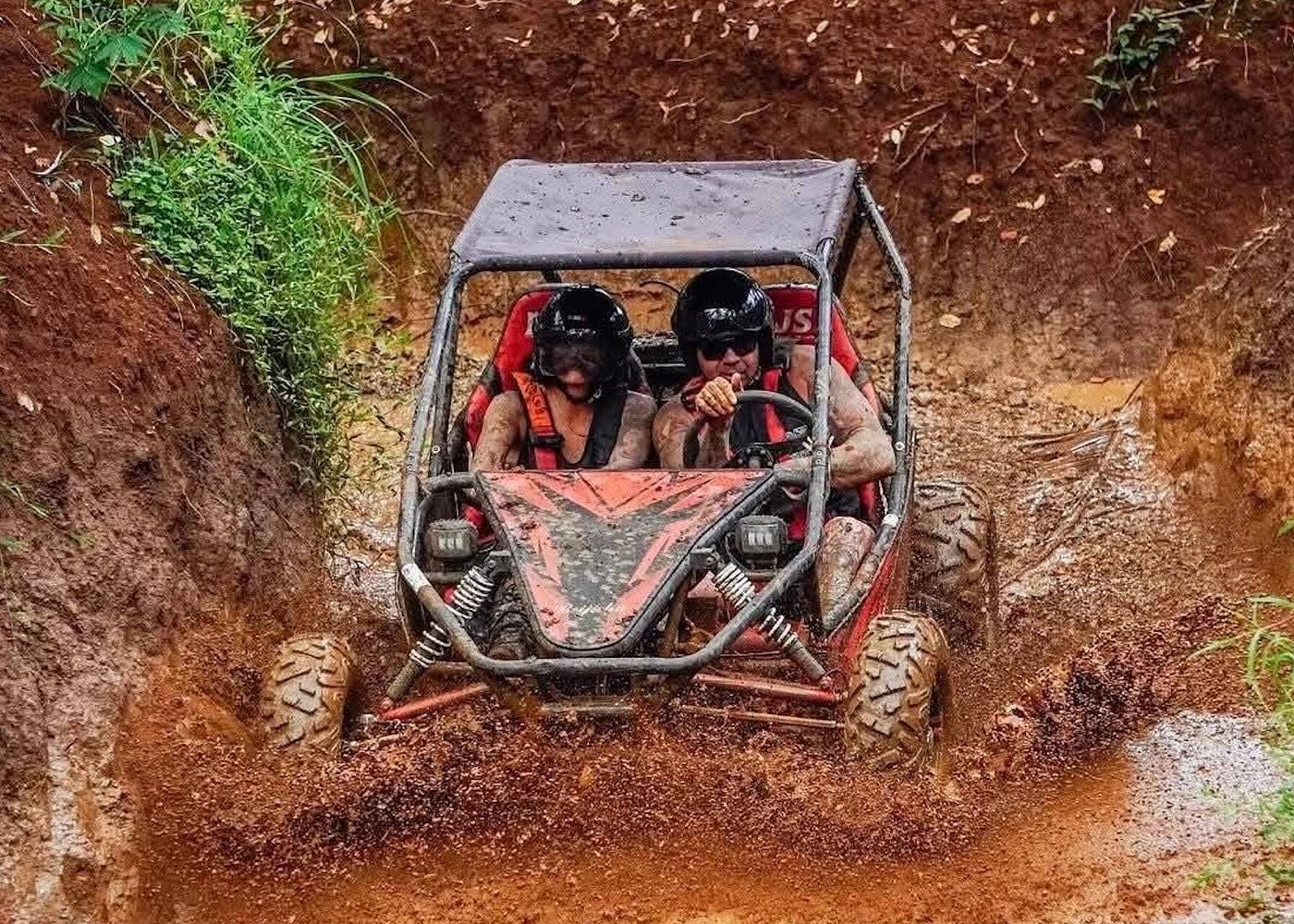 Two-seater UTV buggy on a jungle trail in the Ubud highlands with riders in helmets